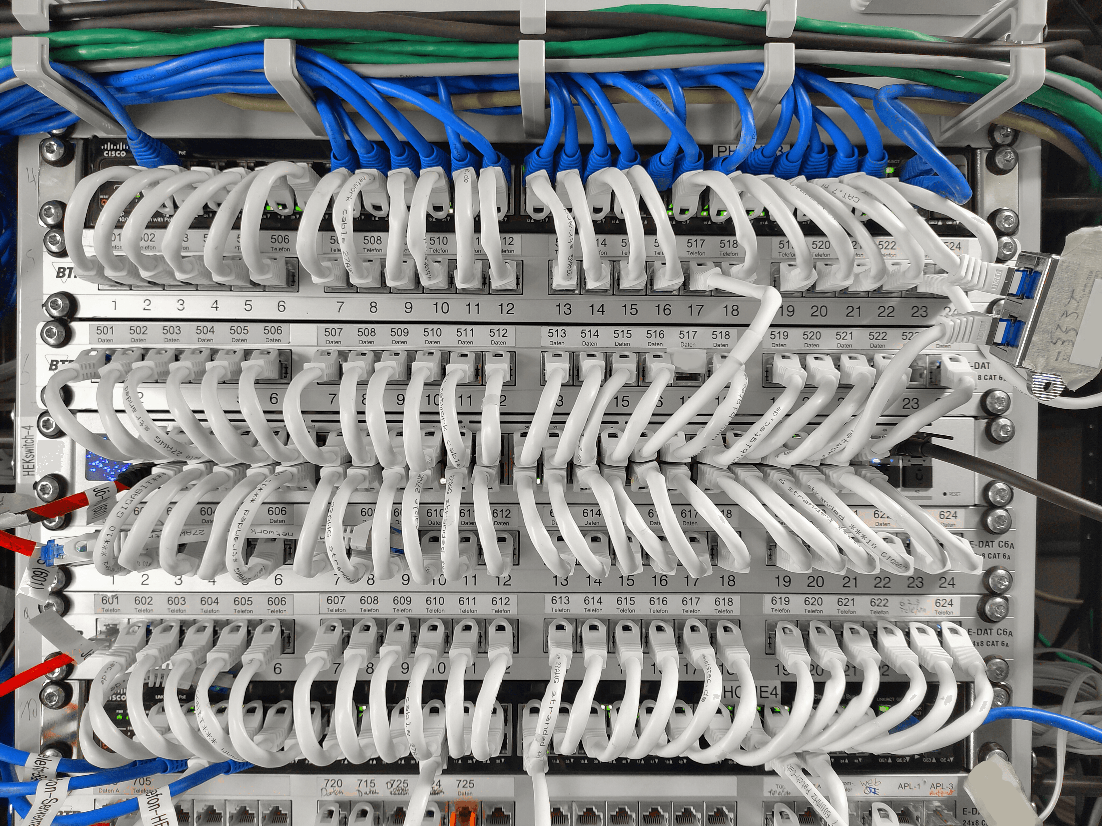 Ein Switch im HEK eigenen Serverraum mit vielen LAN-Kabeln. Ein Netzwerk-Switch mit vielen LAN-Kabeln in einem Serverraum